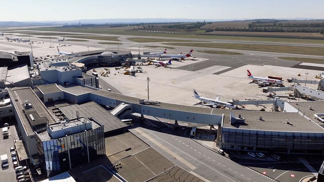 Der Flughafen Wien von oben mit etlichen Flugsteigen und geparkten Flugzeugen.