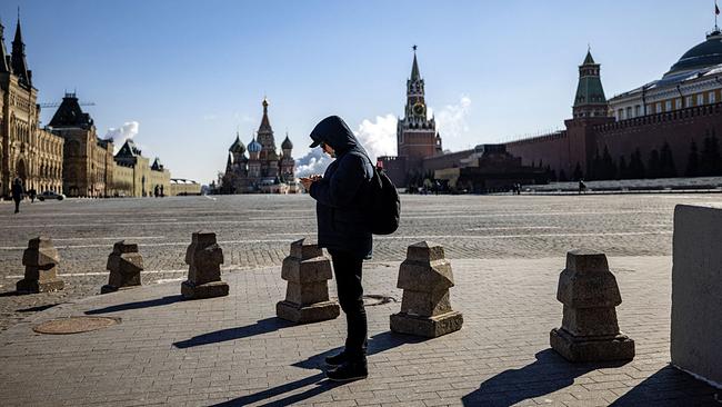 Mann blickt auf Handy auf dem Roten Platz in Moskau