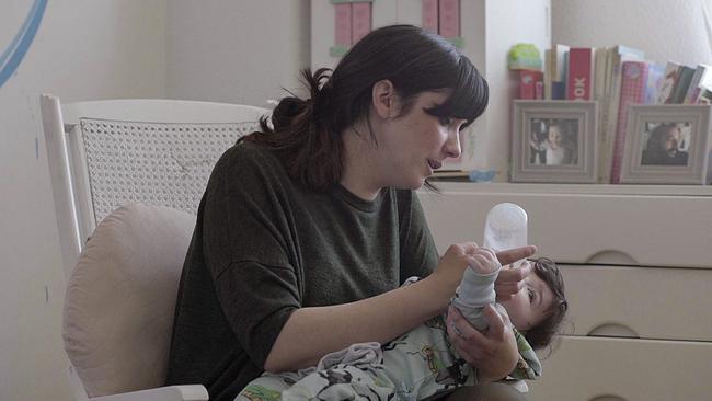 Frau füttert Baby mit Flasche