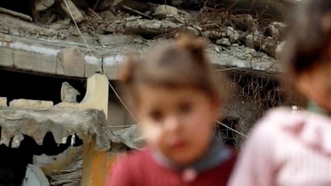 Mädchen vor zerstörtem Haus in Syrien