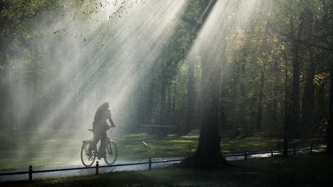 Radfahrerin bei Regen und Sonnenschein