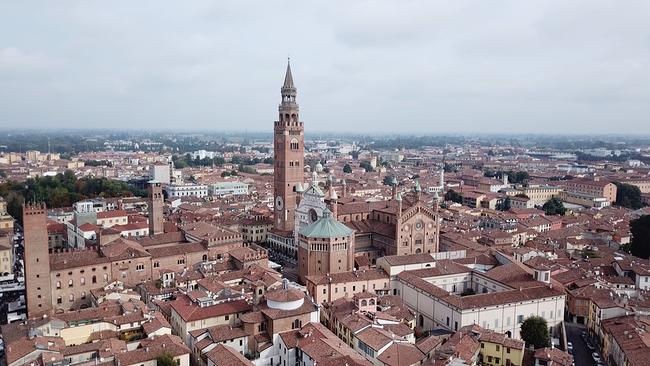 Luftaufnahme. Historische Gebäude, Kirchtürme, Dächer in Cremona von oben betrachtet, viel Ziegelrot