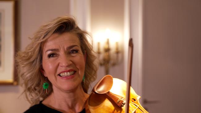 Anne-Sophie Mutter hält eine Stradivari in der Hand, strahlt glücklich