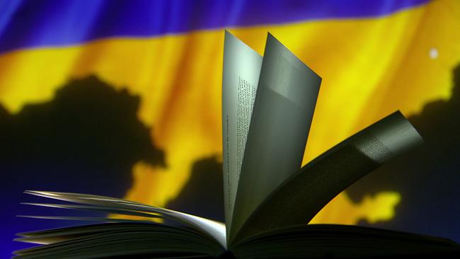 Aufgeschlagenes Buch vor der ukrainischen Flagge