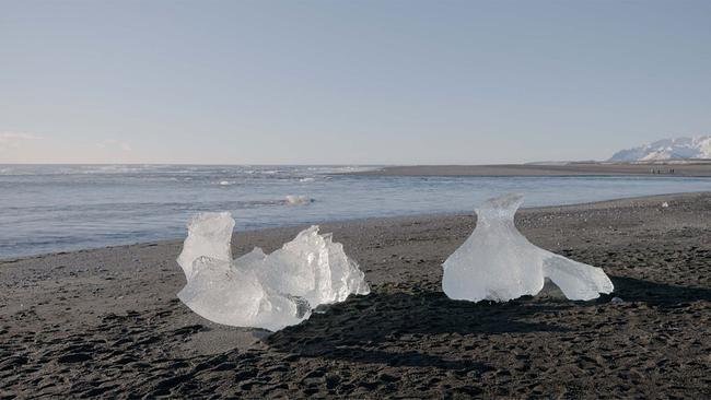 Filmstill "Melt" - zwei Eisklumpen am Sandstrand
