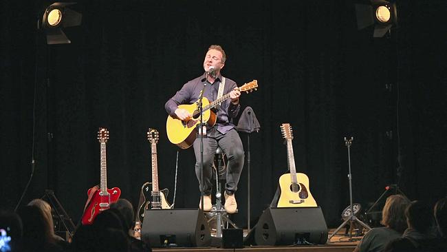 Josh. mit Gitarre singend auf Bühne