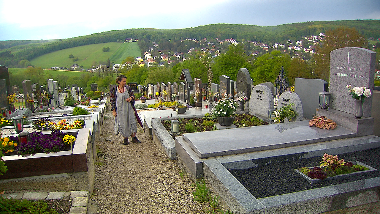 Frau S. am Friedhof beim Grab Ihres Mannes