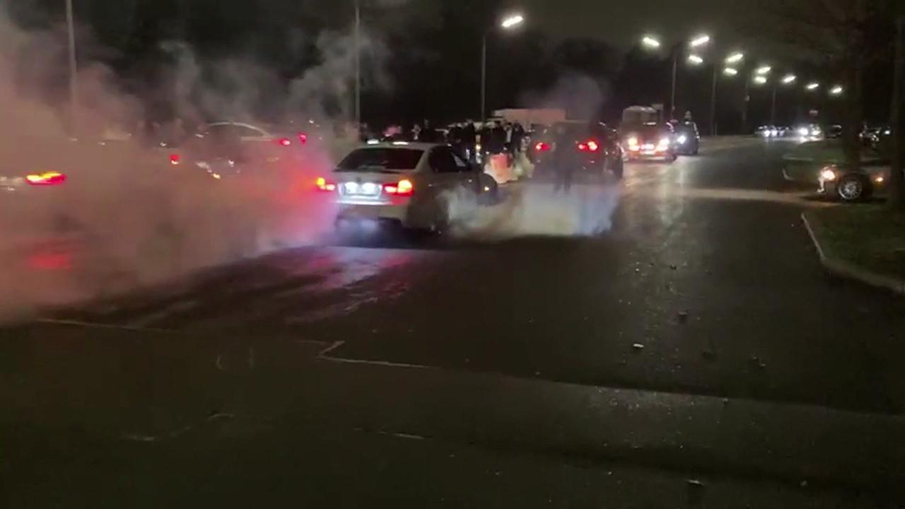 Eine Nachtaufnahme von Autos mit rauchenden Reifen 