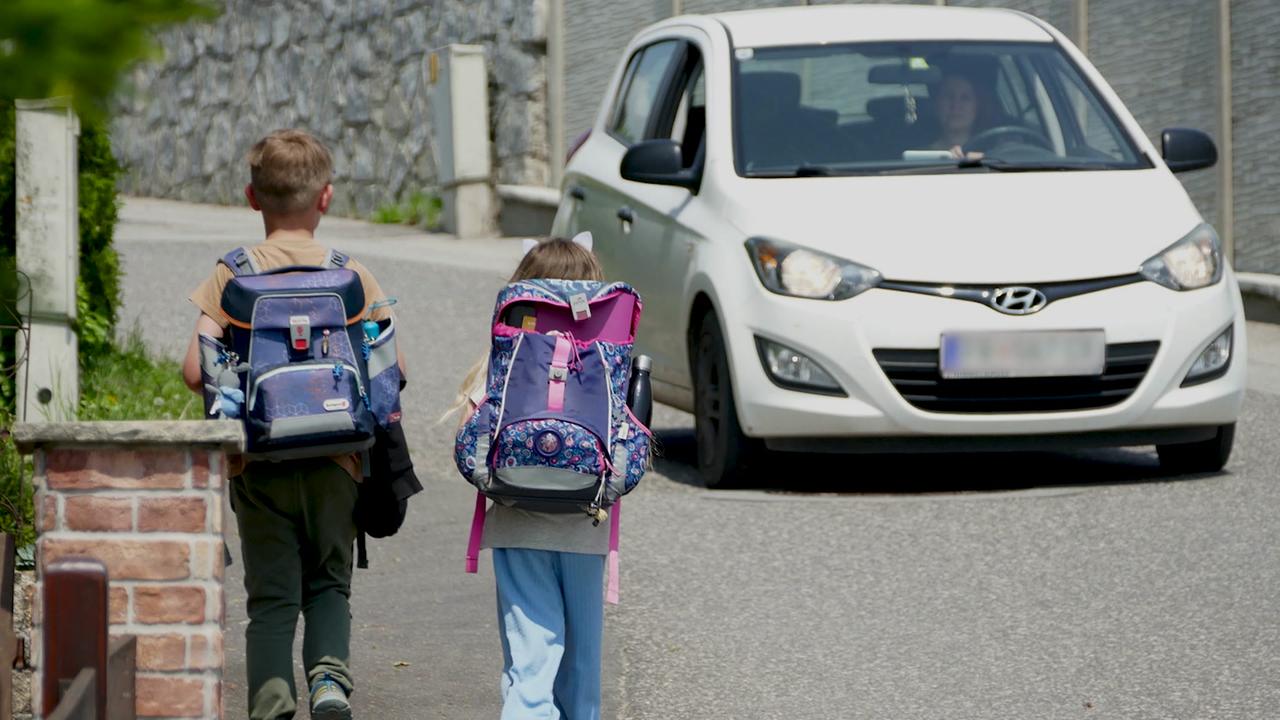 Zu sehen am Bild sind Kinder die am Schulweg dem starken Verkehr ausgesetzt sind