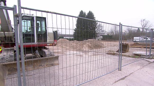 Am Bild ist ein Grünstreifen zu sehen welcher als Lagerplatz für Baufahrzeuge und Baumaterial verwendet wird.