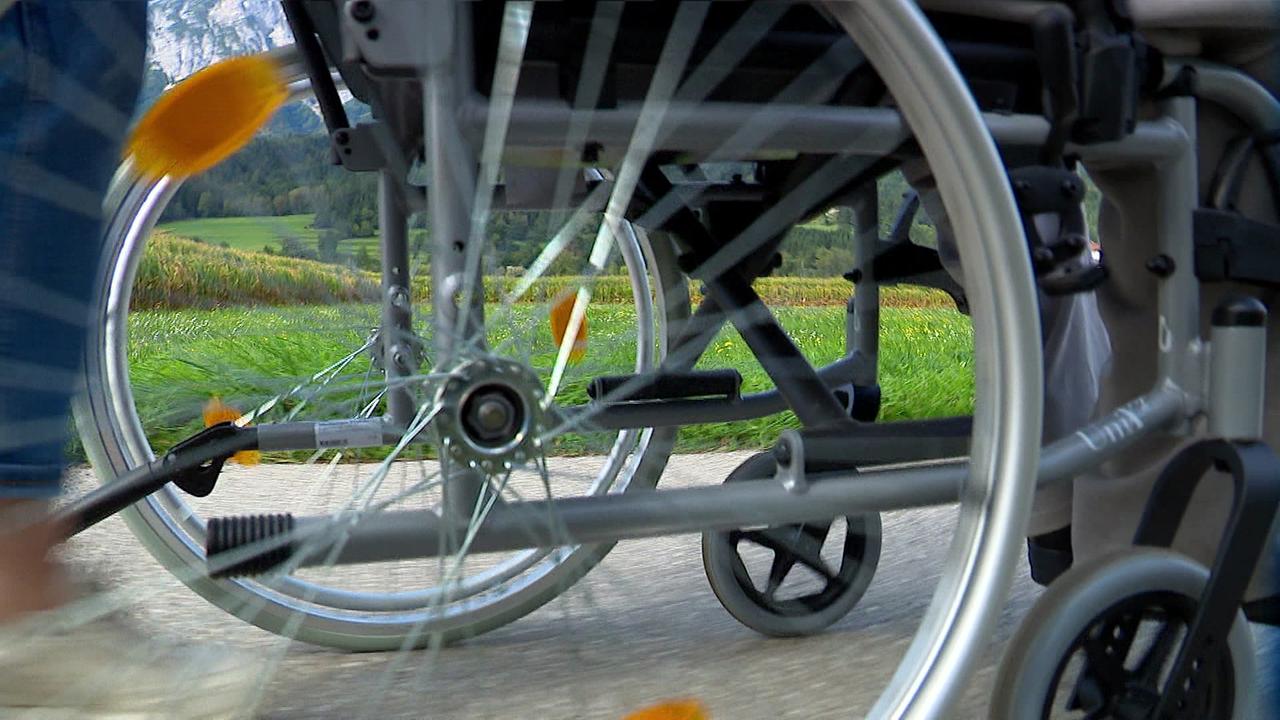 Der große Reifen des Rollstuhles ist zu sehen