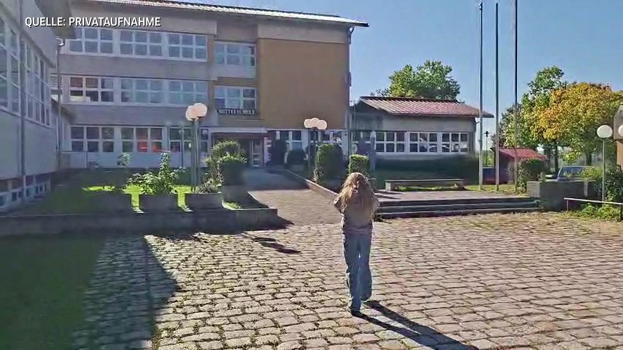 Die Schülerin betritt die Schule in Ostermiething 
