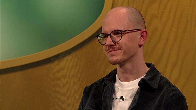 Kevin, Volksschullehrer, sehr kurze, dunkle Haare, Schnauzbart, Brille, schwarzes Sakko