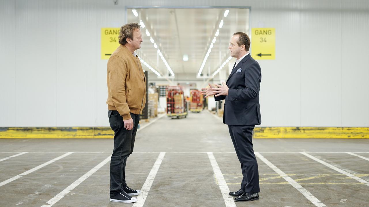 Hanno Settele im Gespräch mit Robert Nagele, dem Vorstand von BILLA, in einer großen Lieferhalle.