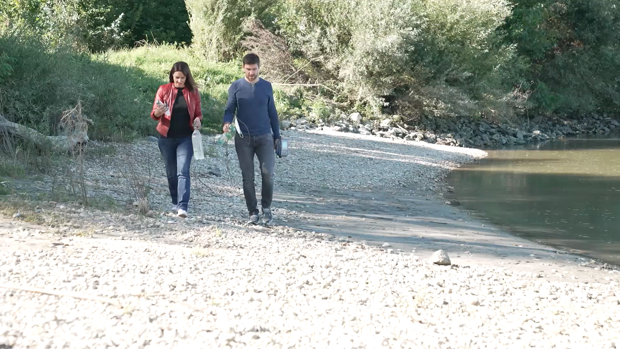 Johannes Mayerhofer von der BOKU und Lisa Gadenstätter spazieren an einem Donaustrand entlang und sammeln Müll ein.