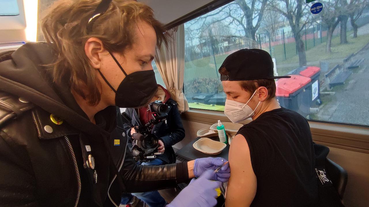 Dr. Marco Pogo impft im Impf-Wohnmobil einen jungen Oberösterreicher in den Oberarm. 