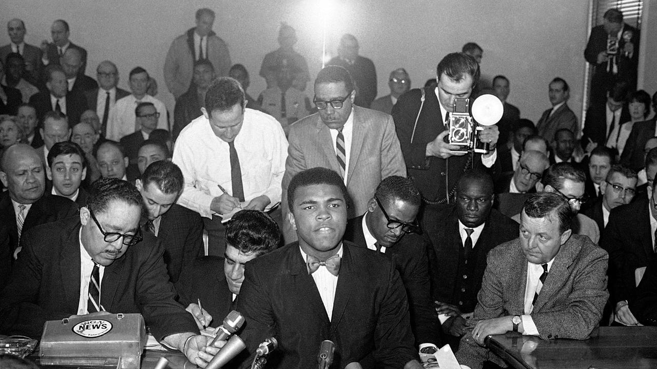 Im Bild: Während die Illinois Athletic Commission zuhörte, sprach der Schwergewichts-Champion Muhammad Ali am 25. Februar 1966 in Chicago. Er nahm an der Kommissionssitzung teil, weil der Gouverneur von Illinois, Otto Kerner, darum gebeten hatte, dass die Kommissionsmitglieder die Erlaubnis für Clay, seinen Titel später in diesem Monat zu verteidigen, noch einmal überdenken sollten. Ali hatte seine bevorstehende Wehrpflicht kritisiert.