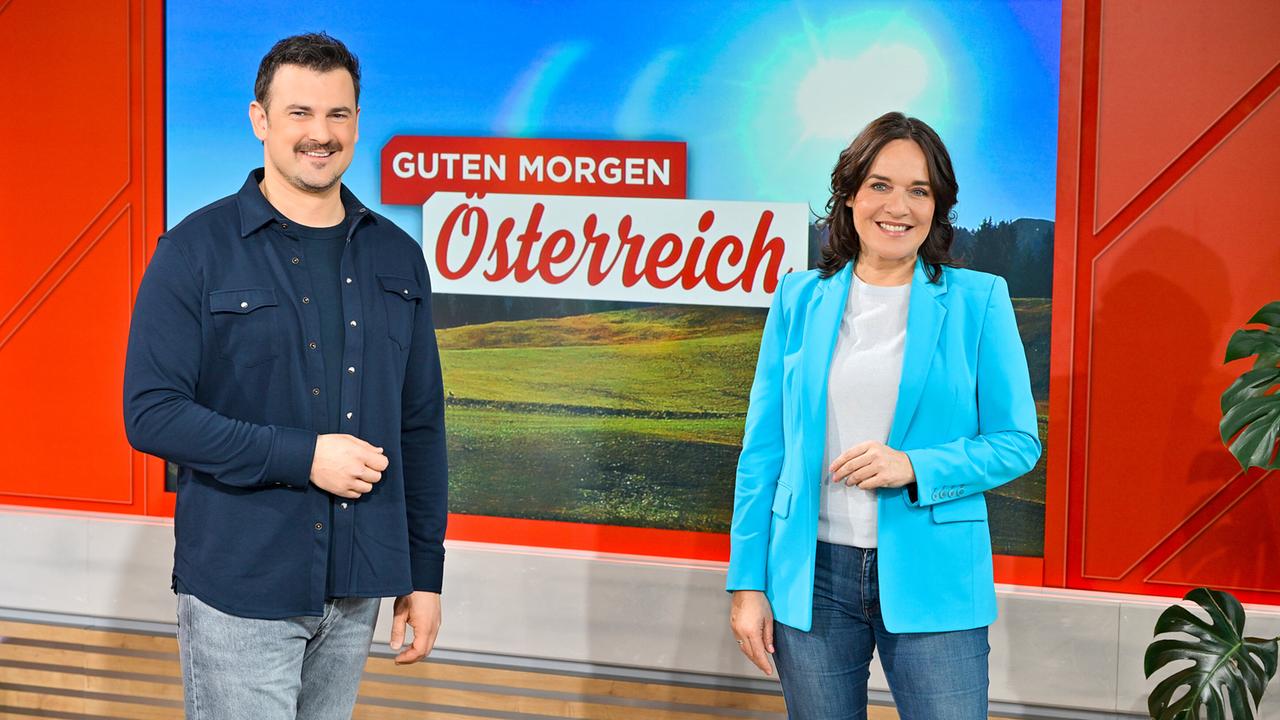 Sigi Fink und Eva Pölzl stehen im Studio von „Guten Morgen Österreich“ vor einem großen Bildschirm.