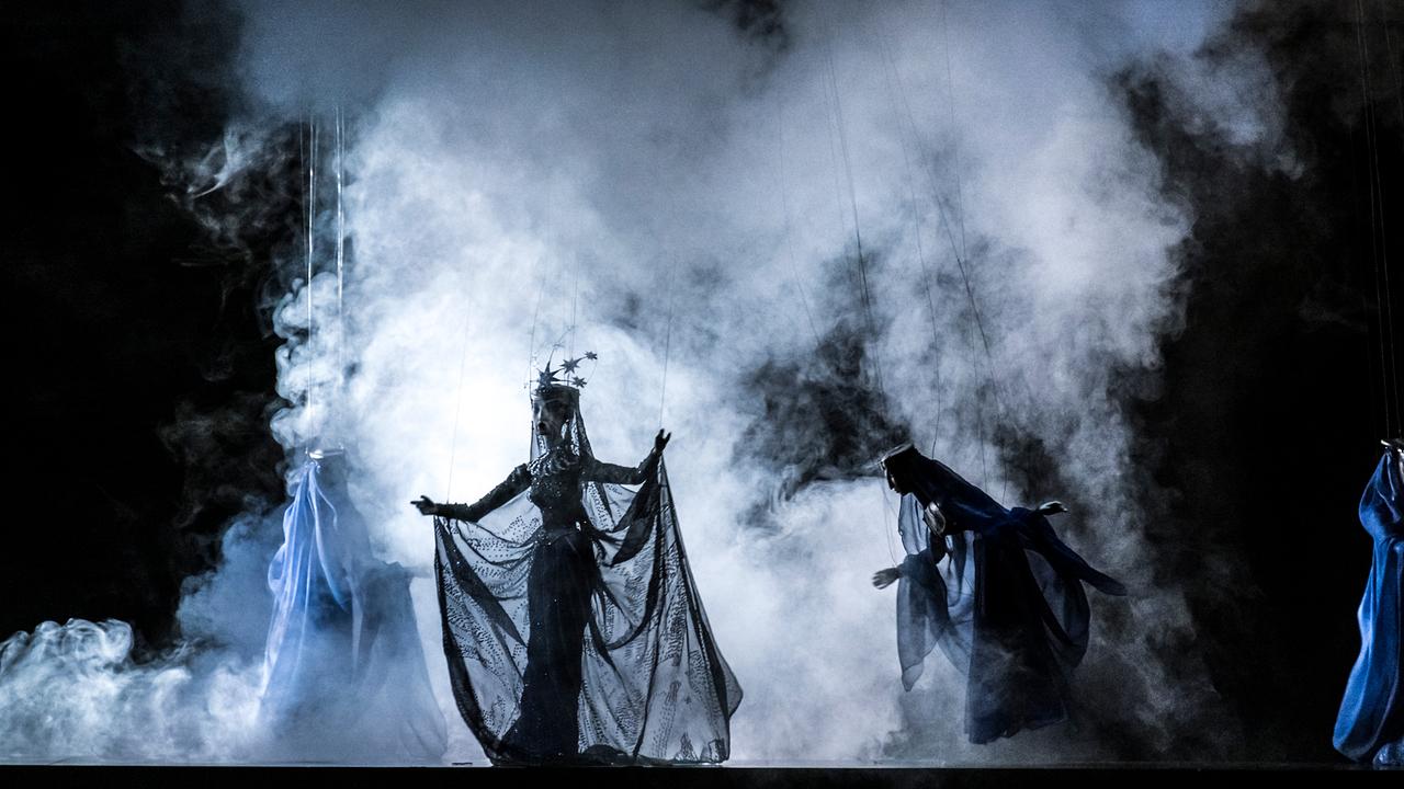 Zwei Puppen aus der Zauberflöte stehen im weißen Nebel. 