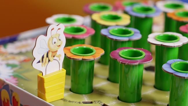 Eine Kartonbiene steht auf dem Spielbrett vom Spiel Honey und sammelt Nektar aus den Blumentrichtern. 