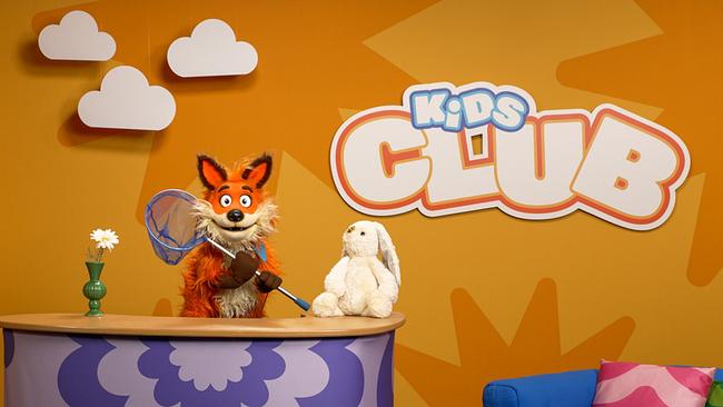 Fuchsi steht im KiDS Club Studio und hält ein kleines Fischernetz in der Hand.