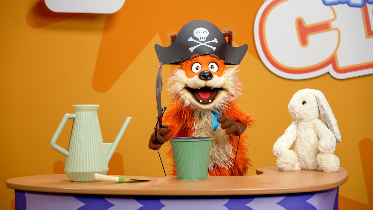© ORF/Steiner Familyentertainment Fuchsi ist als Pirat verkleidet und steht mit einem Topf und einer Gießkanne im KiDS CLUB Studio.
