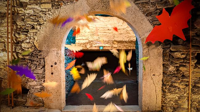 © Kultur-Betriebe Burgenland Vor und hinter einem alten Torbogen in der Burg Schlaining flattern viele bunte Fledermäuse.