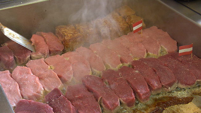 Kalbfleischstücke in verschiedenen zartrosatönen braten auf dem Grillrost