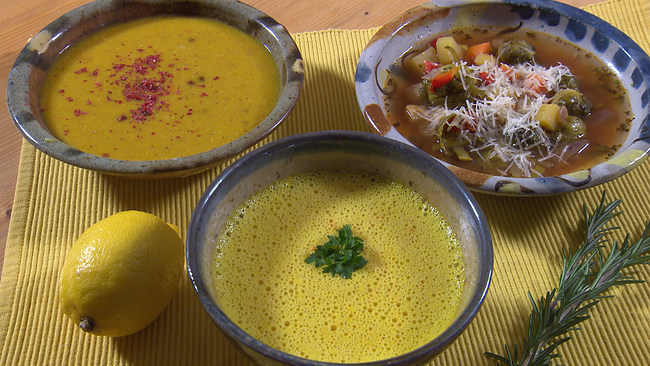 Drei tiefe Teller mit unterschiedlichen Suppen. Zwei davon cremig mit Kräutertopping, eine Kohlsprossensuppe mit Parmesamtopping