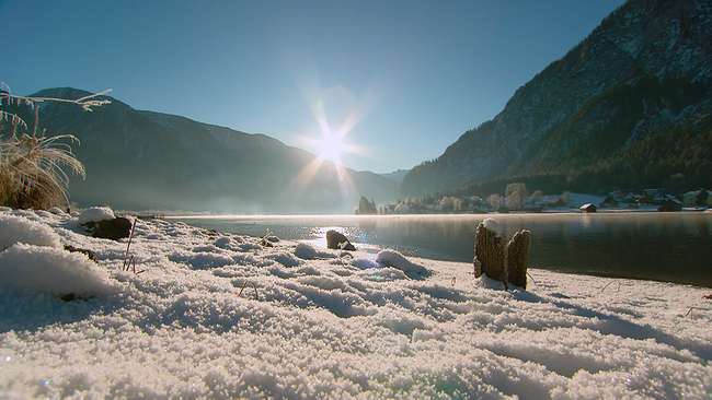 Hallstätter See im Winter mit Schnee im Vordergrund und Sonne