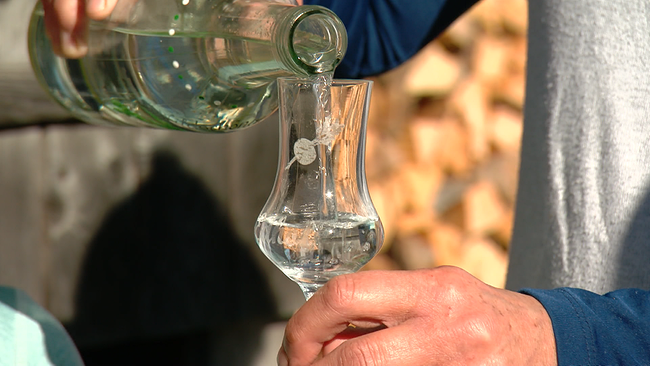 © ORF NÖ Eine Person, deren Hände zu sehen sind, schenkt etwas selbstgebrannten Schnaps in ein bauchiges Schnapsgläschen
