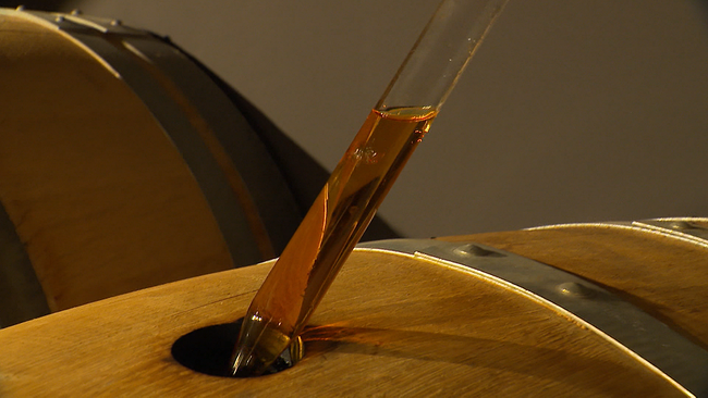 Schnaps wird aus Holzfass gezogen
