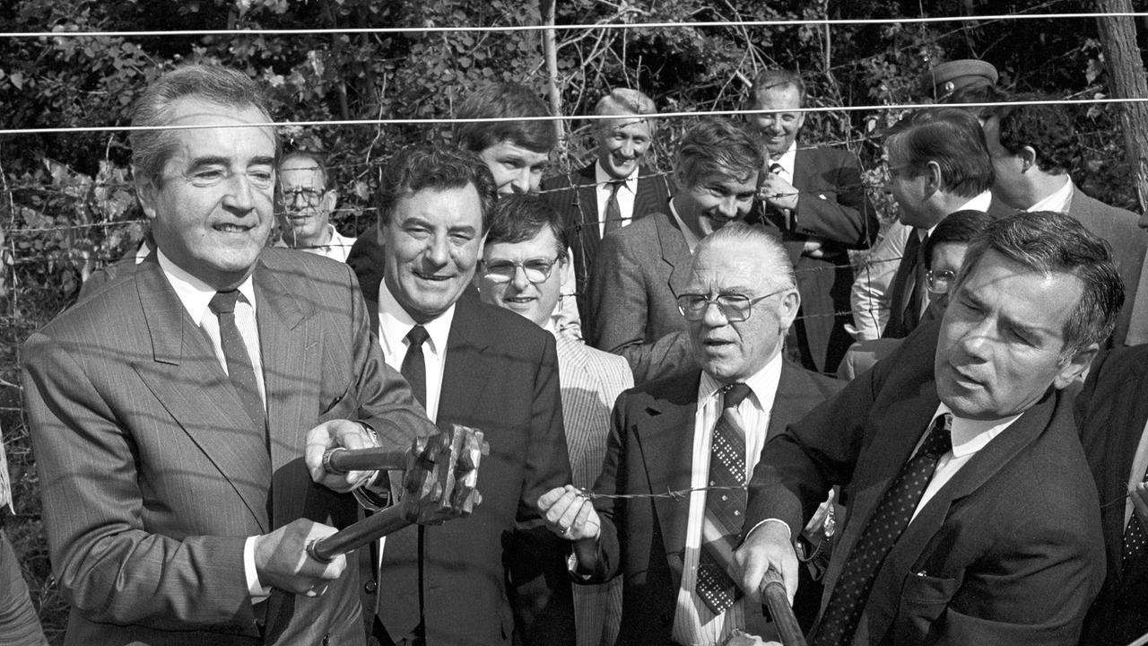 Alois Mock (l.), Österreichs Außenminister, und sein ungarischer Amtskollege Gyula Horn (r.) beim Durchtrennen des Eisernen Vorhanges am 27. Juni 1989.