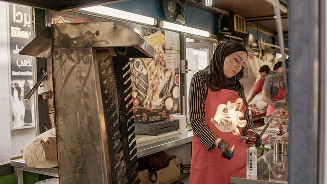 Ilham bereitet den Grill vor. Sie und ihr Mann betreiben eine Fleischerei auf dem Brunnenmarkt in Wien.