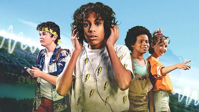 Vier Kinder, der Junge im Vordergrund trägt Kopfhörer. Er blickt konzentriert.