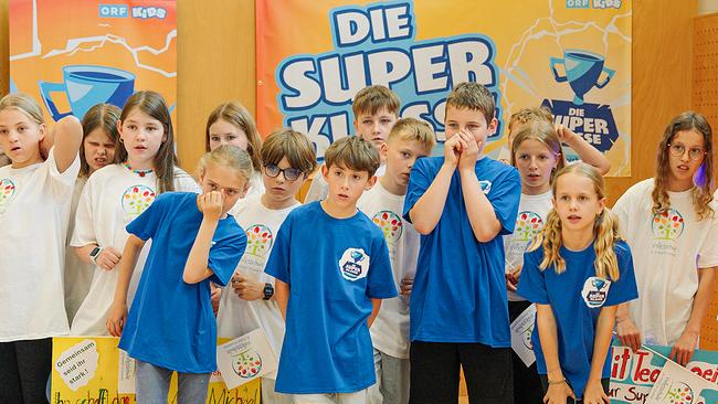 Kinder in blauen und weißen T-Shirts halten die Daumen