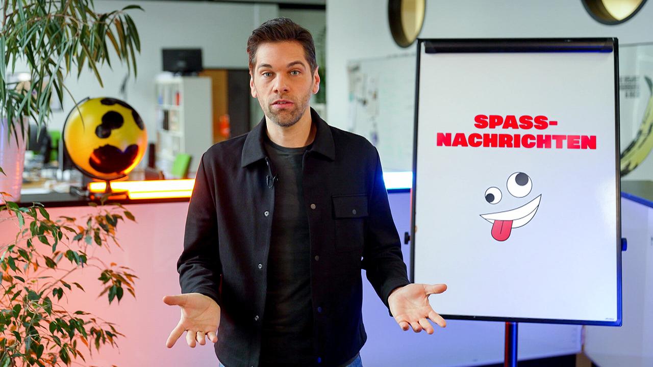 Ein Mann erklärt etwas. Neben ihm auf einem Board steht "Spaßnachrichten" mit einem Lach-Emoticon.