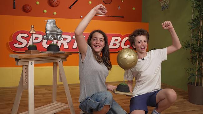 Ein junger Bursche und ein Mädchen freuen sich. Sie strekcen die Arme in die Luft.