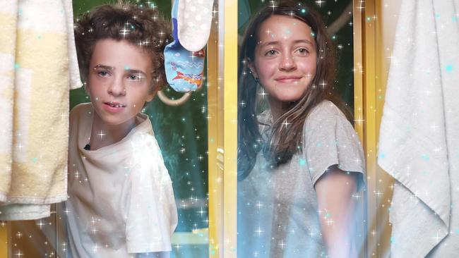 Ein junger Bursche und ein Mädchen schauen lächelnd aus dem Fenster