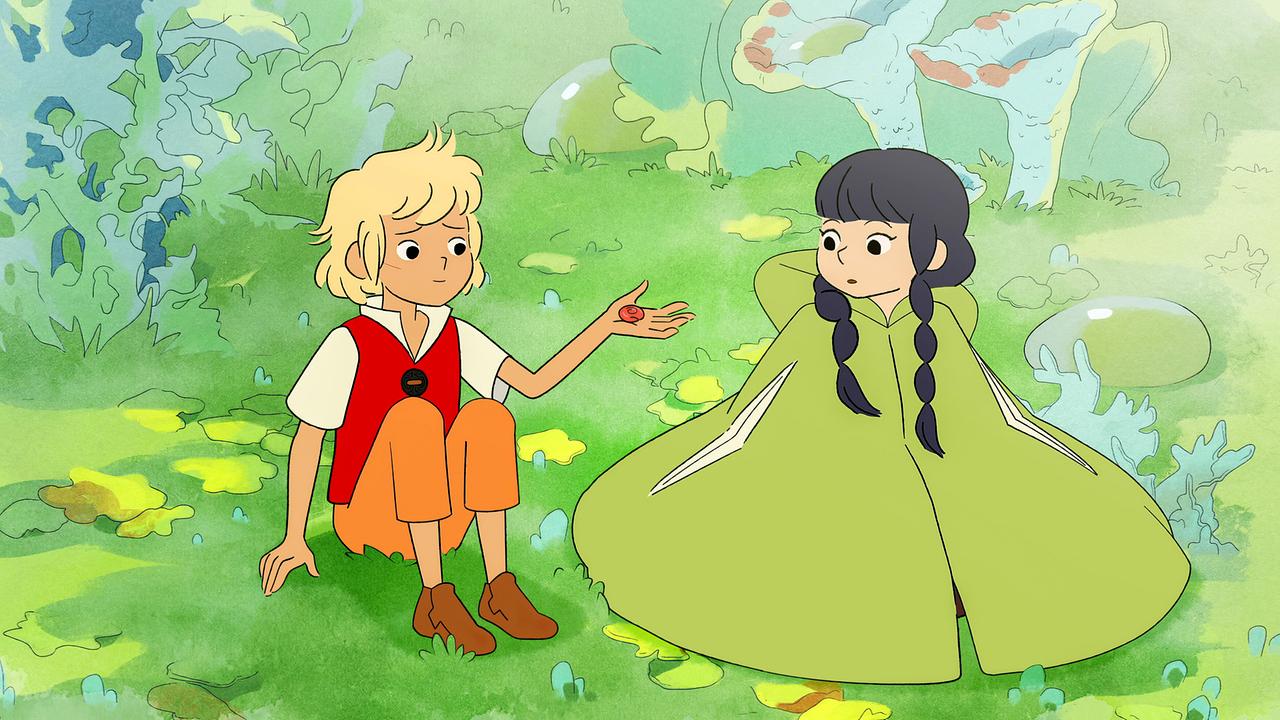 © ORF/ZDF Studios/Tant Mieux Prod/Umedia Ein blonder Junge und ein Mädchen mit einem grünen Umhang sitzen auf einer Wiese.