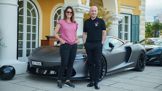 Lisa Gadenstätter und Florian Koschat stehen vor parkenden Luxusautos vor einer Villa am Wörthersee 