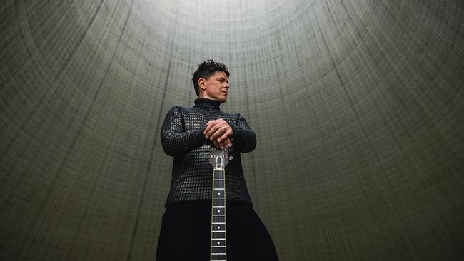 © Bild: Marvin Stroeter Michael Patrick Kelly steht in einem hohen, runden Betonraum und hält eine Gitarre vor sich.