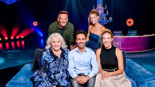 Marika Lichter, Danilo Campisi und Maria Santner sitzen auf einer blauen Samtcoach, dahinter stehen Andi Knoll und Mirjam Weichselbraun im "20 Jahre Dancing Stars - Magic Moments"-Studio