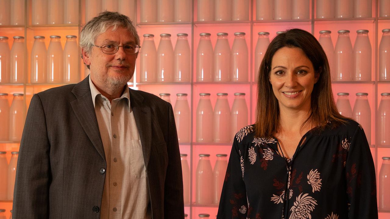 Lisa Gadenstätter und Ernährungswissenschafter Jürgen König vor einer Wand voller Milchflaschen