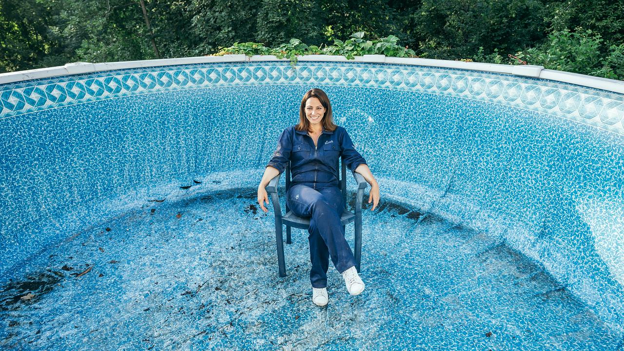 Lisa Gadenstätter sitzt im Blaumann auf einem Plastiksessel in einem verweisten Pool