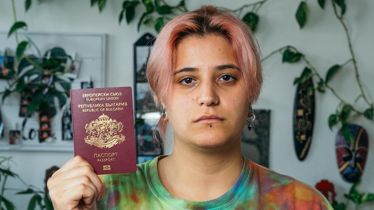Ebru Sokolova sieht in die Kamera und zeigt ihren Pass her