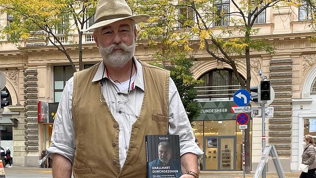 Älterer Mann mit Vollbart und Hut in der Fußgängerzone.