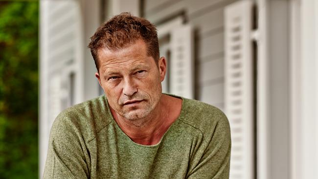 der Schauspieler und Regisseur Til Schweiger lehnt an einem Geländer auf einer Hausveranda