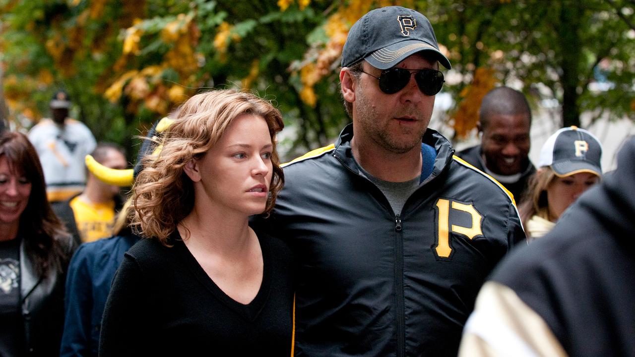 Ein Mann in Pittsburgh-Pirates-Jacke und eine Frau gehen eng nebeneinander durch eine Menschenmenge