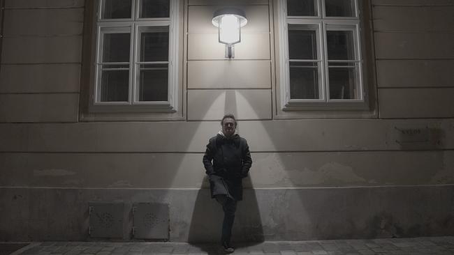 Moderator Hanno Settele steht mitten in der Nacht in einer dunklen Gasse